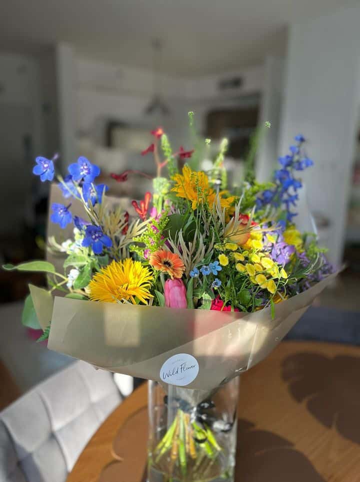 זר פרחים כחולים וצהובים בתוך אגרטל